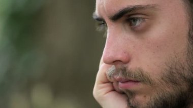 Düşünceli üzgün yakışıklı genç bir adam üzerinde odaklanın. Dalgın genç adam