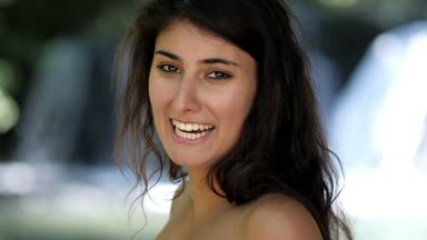 kameraya bakarak gülen güzel genç esmer yakın portarit - arka planda şelaleler