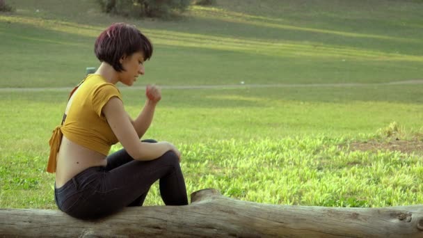 愤怒沮丧的年轻妇女的画像投掷棍子在公园 — 图库视频影像
