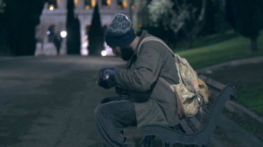 Evsiz şehir parkta geceleri, sayımların onun sadaka yürüme.