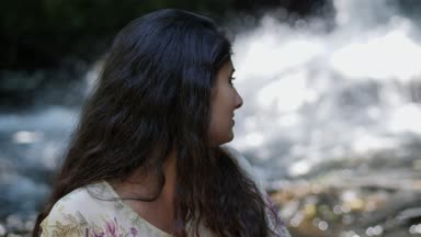 Şelalenin yakınındaki gülümseyen güzel esmer