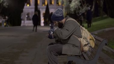 Yalnız dilenci onun sadaka geceleri, cheking bankta oturmak