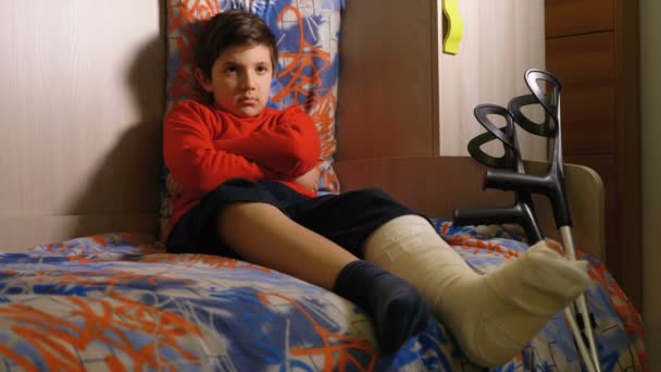 愤怒哀伤的孩子以腿的石膏单独 — 图库视频影像