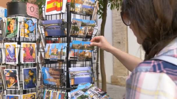 シヴィリアの土産物店でポストカードを選ぶ観光客 — ストック動画
