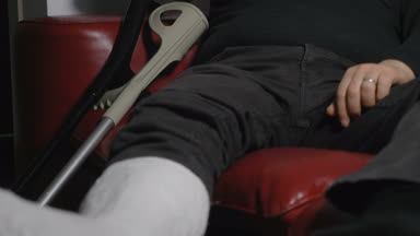 Kırık bacak kanepede yalnız dalgın ve üzgün olgun adam