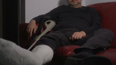 üzgün ve dalgın adam bacak sıva ile tek başına evde yaralı