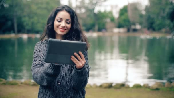 魅力的な笑顔若い女性デジタル タブレット 屋外のスクロール — ストック動画