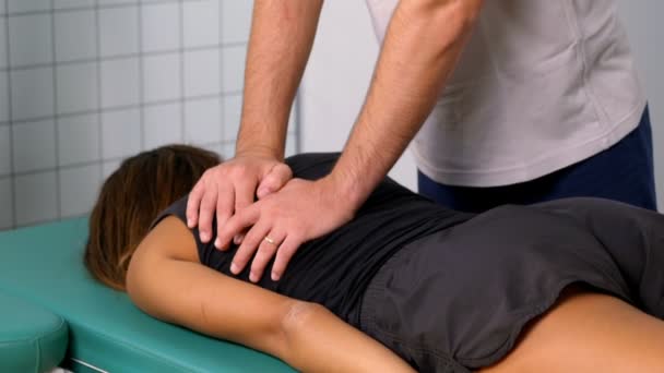 Masajes fisioterapeutas con presión en la espalda de un paciente — Vídeo de stock