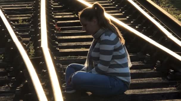 自杀抑郁症坐在铁轨上的年轻郁闷的女人 — 图库视频影像