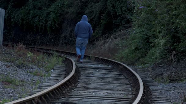 Μοναχικός Άντρας Την Κουκούλα Περπάτημα Κατά Μήκος Της Σιδηροτροχιάς Μοναξιά — Αρχείο Βίντεο