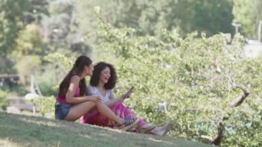 Dijital tablet kullanarak çim üzerinde mutlu ve kaygısız arkadaşlar