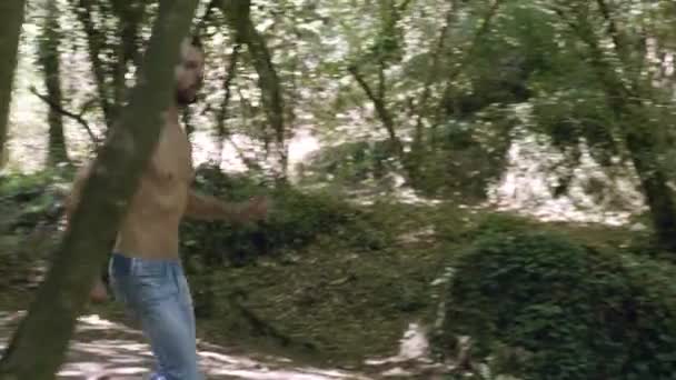 solitaire Beau jeune homme courant à travers le bois. Dans la nature 