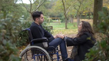 üzgün Engelli genç adam içinde A tekerlekli arkadaşı tarafından - açık teselli