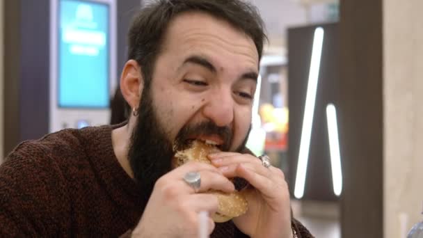 ファーストフードでハンバーガーを食べて変なラテン男 — ストック動画