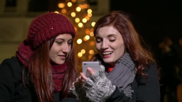 Leende Unga Flickvänner Gatan Vid Jul Använda Smartphone — Stockvideo