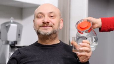 Komik ve komik adam içecekler su ve o bu gibi değil gibi davranarak
