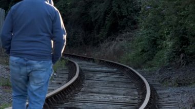 Trende yürüyen üzücü yalnız kukuletalı adam izler. Yalnızlık, üzüntü