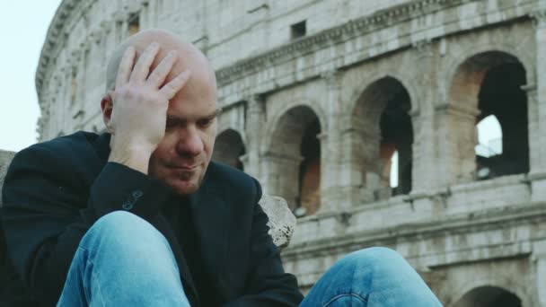 Στοχαστικός Λυπημένος Άνθρωπος Σκέφτεται Ανησυχίες Προβλήματα Κολοσσαίο Στο Παρασκήνιο — Αρχείο Βίντεο