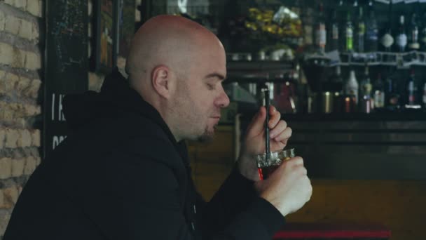 体贴的悲伤孤独的秃头男子喝他的鸡尾酒在酒吧 — 图库视频影像