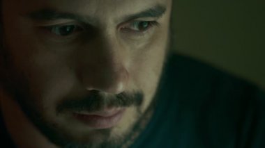 karanlık kameraya bakarak ciddi yakışıklı adam