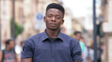 Emin çekici genç siyah Afrika adam geçiş silah ve kamera gülümsüyor