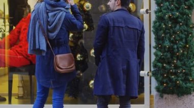 Mutlu çift Noel'de vitrin sokakta bakarak konuşuyor
