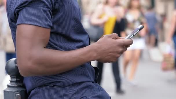 美国黑人男子的手打字在智能手机在城市 — 图库视频影像