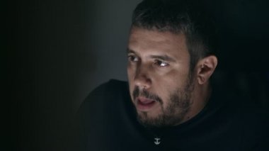 Karanlıkta tek başına mastürbasyon yapan, porno izleyen bir adam.