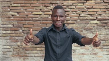 başarı, zafer. Genç siyah erkek gülümseyen başparmak yukarıya - yavaş hareket yapar