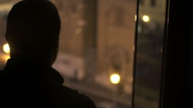 pencereden karanlıkta yalnız adam city adlı geceleri görünüyor.