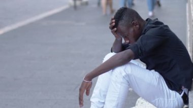 depresif endişeli genç Afrika adam sokakta oturan