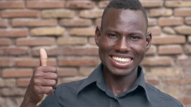 iyimserlik, pozitif. Genç gülümseyen adam başparmak yukarı - ağır çekim yapma siyah