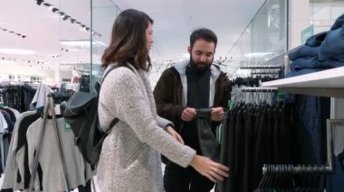 Genç çift pantolon bir giyim mağazası - yavaş hareket bakarak