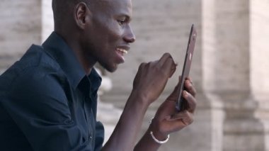 Mutlu Amerikan Afrika genç adam onun tablet Kaydırma gülümseyen-açık
