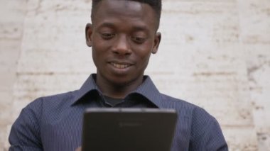 Gülümseyen siyah Afrika öğrenci dijital tablet-açık kullanma