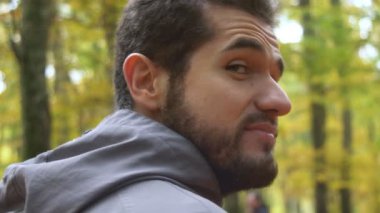 Çekici genç adam kameraya gülümseyen ormandaki hiking