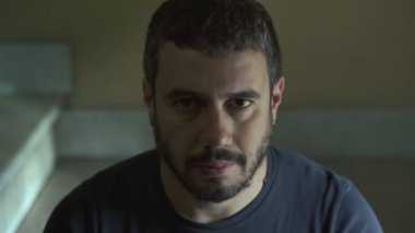 Kameraya bakarak merdivenlerde ciddi deli yalnız adam