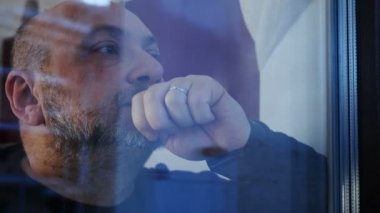 Pencereden bakan dalgın endişeli olgun adam