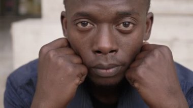 kafasını yetiştirme ve kameraya bakarak üzgün çaresiz genç siyah adam