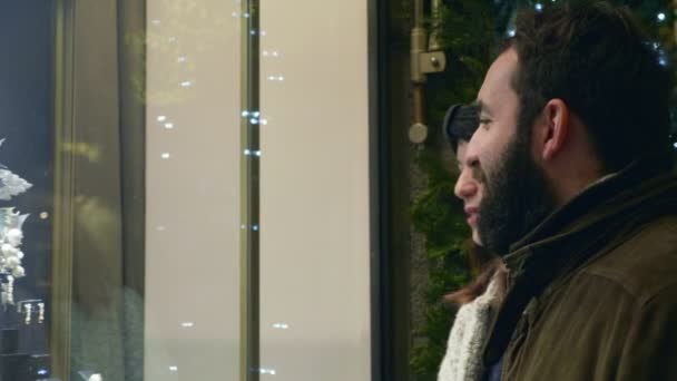 クリスマスの時に店の窓を見て愛の魅力的なカップル — ストック動画