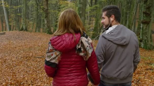 Ρομαντικό Νεαρό Ζευγάρι Περπάτημα Στο Δάσος Ακούσετε Μουσική Πίσω Όψη — Αρχείο Βίντεο