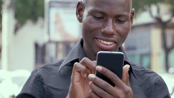 Lächelnder Junger Mann Aus Afrika Mit Smarthone Freien — Stockvideo