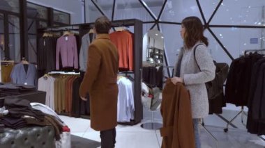 Adam karısını bir giyim mağazası tarafından yardımcı bir kat çalışır