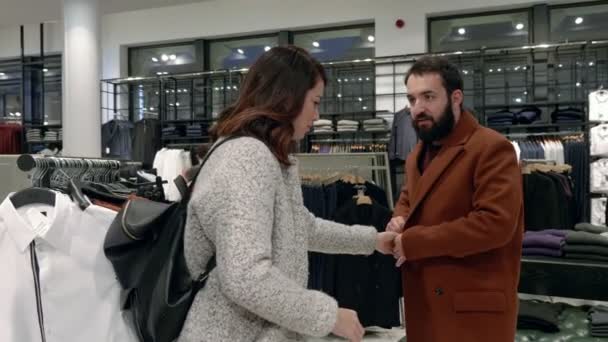 Женщина Помогает Мужу Носить Пальто Магазине Одежды Замедленная Съемка — стоковое видео