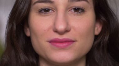 Kameraya, ağır çekim gülümseyen güzel genç esmer