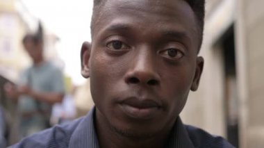 ciddi gururlu genç adam şehirde kamera bakıyor