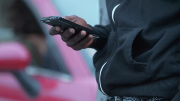 黑衣人的手打字在智能手机在街上 — 图库视频影像