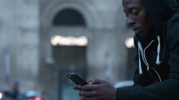 Profilo Giovane Incappucciato Nero Africano Uomo Digitando Sul Suo Smartphone — Video Stock
