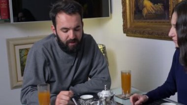 young couple chatting during breakfast in the morning - slow motion