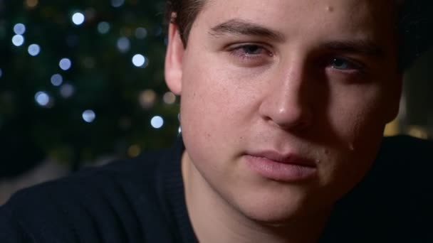 カメラは クリスマスの時期を見て孤独な悲しい若者のクローズ アップ — ストック動画